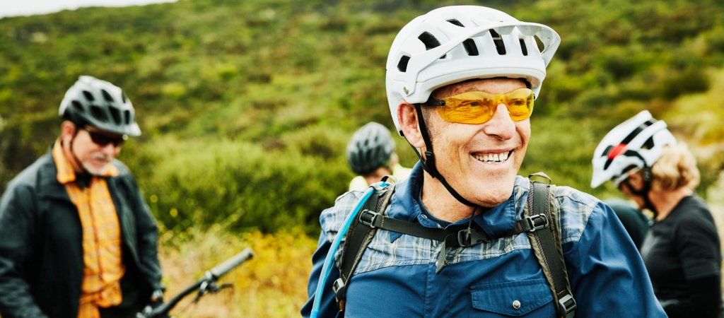 Portrait of smiling senior man hanging out with friends before early morning mountain bike ride
